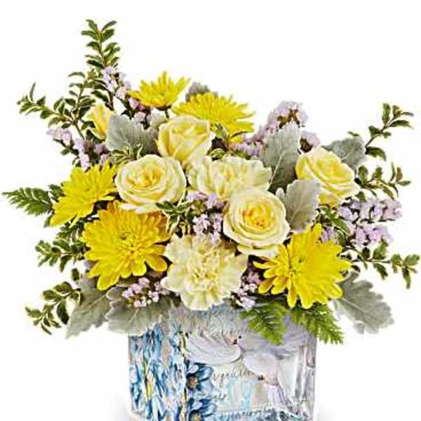 Yellow and white flower arrangement in a patterned glass vase