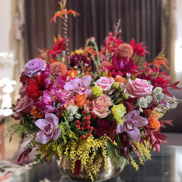 Colorful mixed flower arrangement in a gold vase