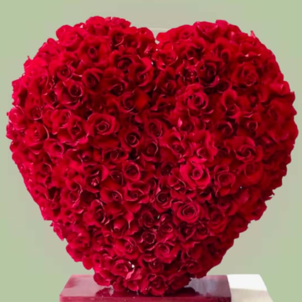 Heart-shaped arrangement of red roses on a pedestal