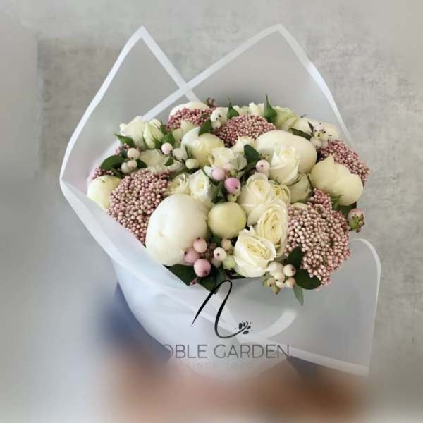 Bouquet of white roses and pink berries wrapped in white paper