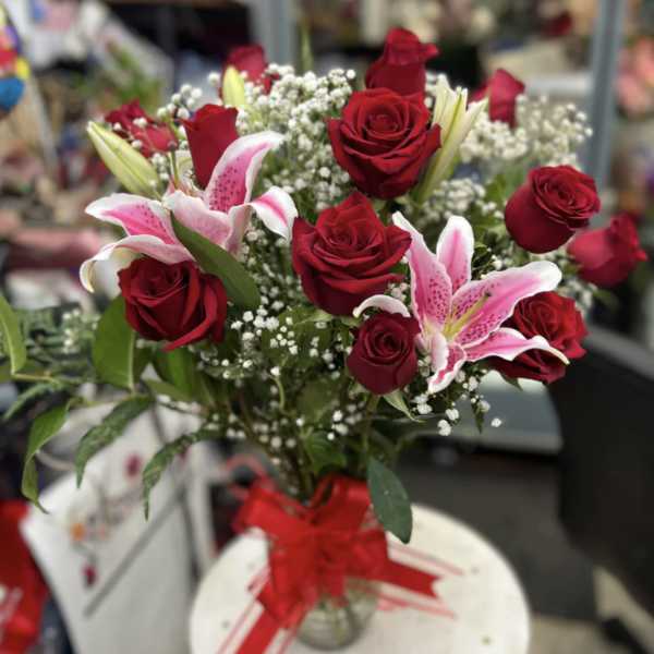 Bouquet of red roses and pink lilies in a glass vase