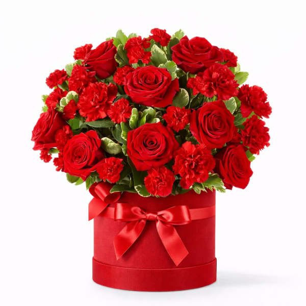 Red roses and carnations in a red hatbox with a ribbon