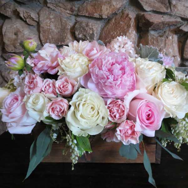 Pink and white rose arrangement in a wooden box
