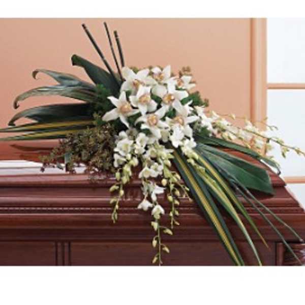 White orchid arrangement on a casket with long dark leaves