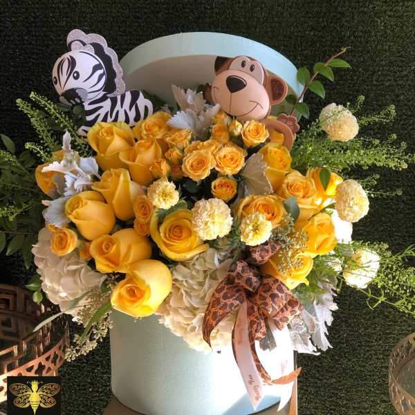 Yellow rose and white hydrangea hatbox arrangement with zebra and monkey decorations