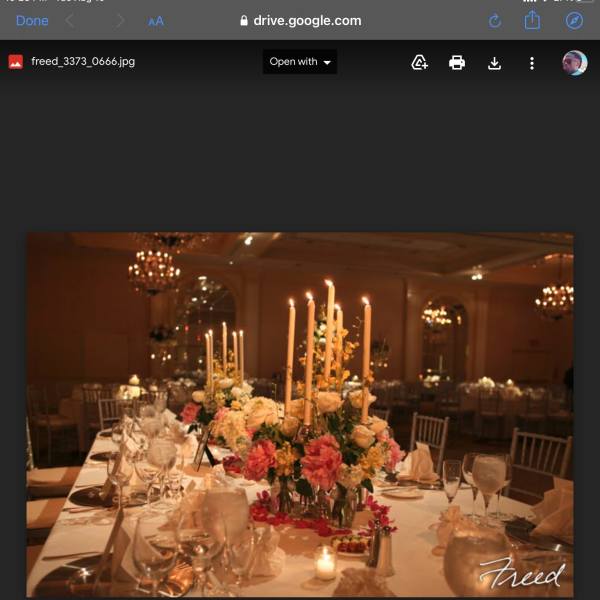 Tall floral centerpieces with candles on a decorated banquet table