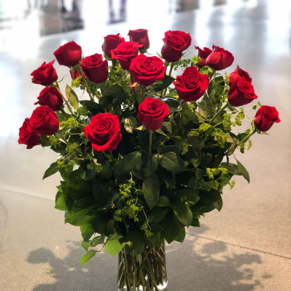 Red roses arranged in a clear glass vase