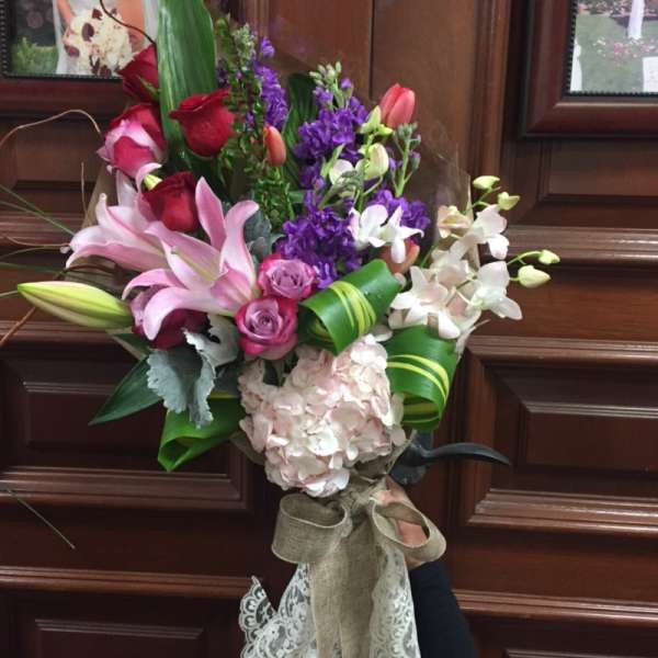 Bouquet of pink lilies, roses, purple flowers, and white orchids