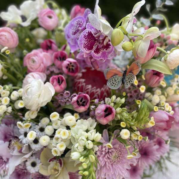Mixed bouquet of pink, white, and purple flowers with orchids and tulips
