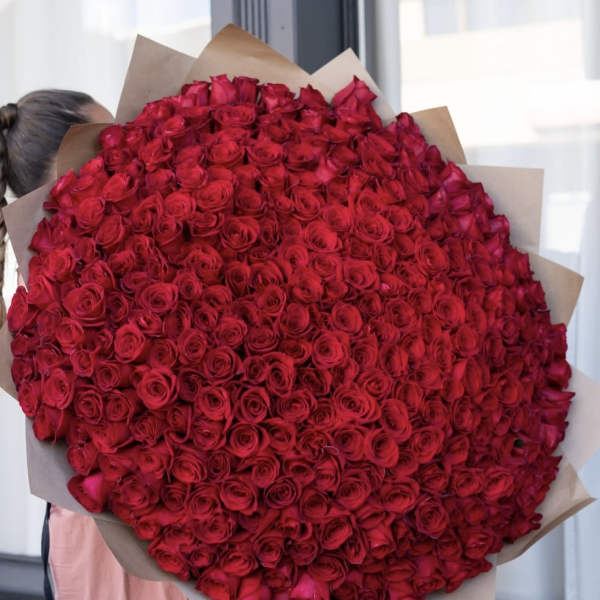 Large bouquet of red roses wrapped in brown paper