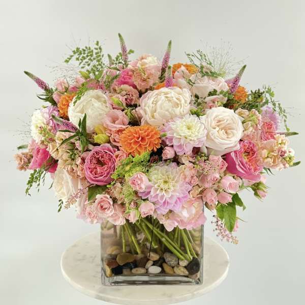 Pink and white mixed bouquet in a square glass vase