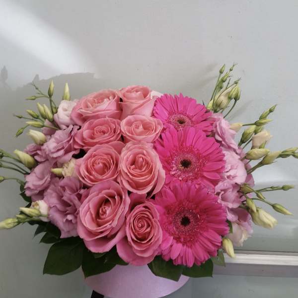 Pink roses and gerbera daisies in a round box arrangement