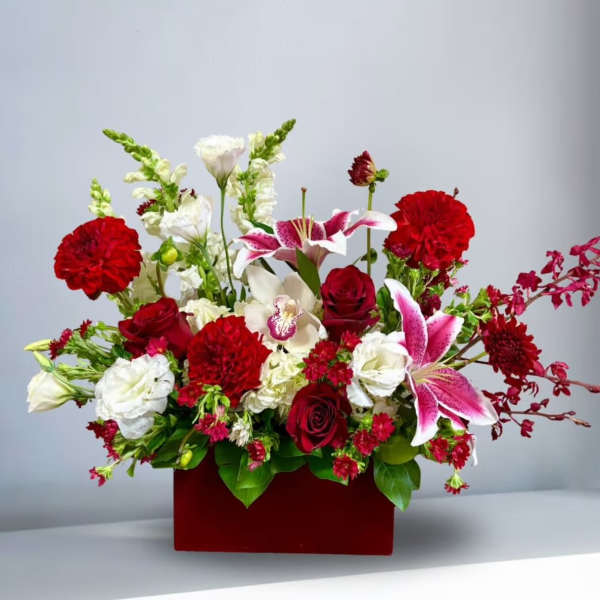 Mixed bouquet of red, white, and pink flowers in a red box