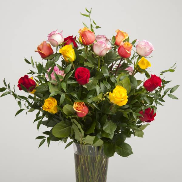 Tall bouquet of multicolored roses in a clear glass vase