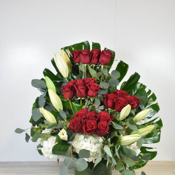 Red roses and white lilies arranged in a green vase