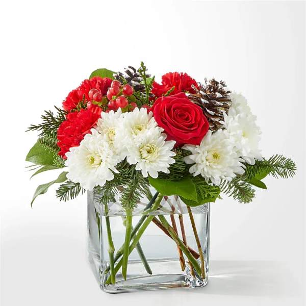 Red and white flowers arranged in a clear glass vase