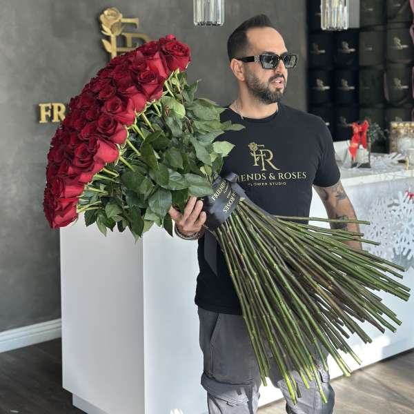 Large bouquet of red roses held by a man in sunglasses
