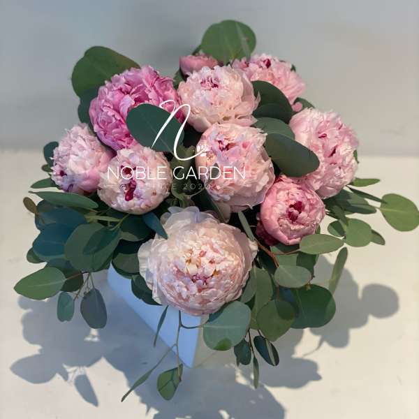 Pink peony bouquet with eucalyptus in a white vase