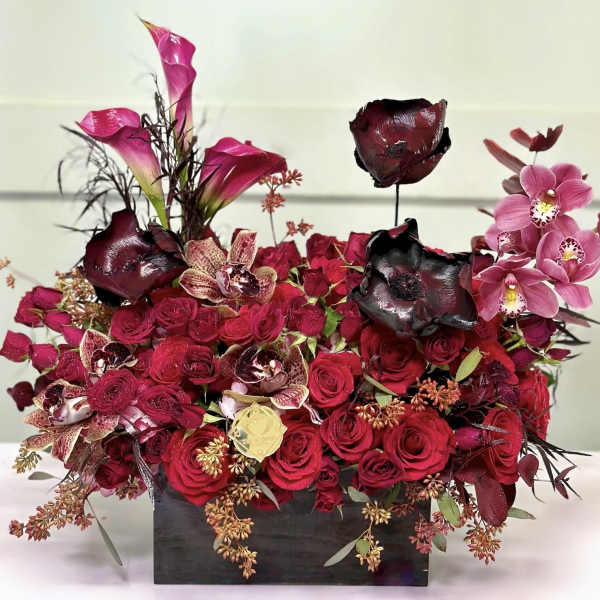 Red rose arrangement with pink orchids in a black rectangular vase