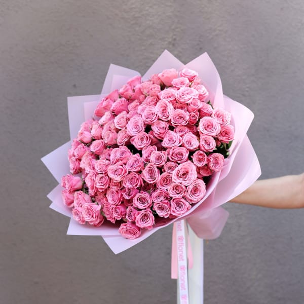 Large bouquet of pink roses wrapped in pale pink paper