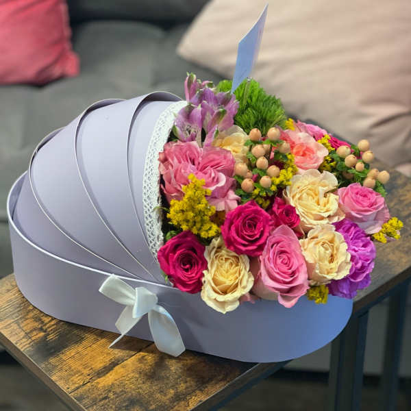 Bouquet of pink, cream, and purple roses in a lavender hat box