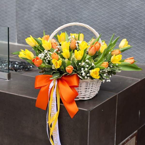 Basket of yellow and orange tulips with a large orange ribbon