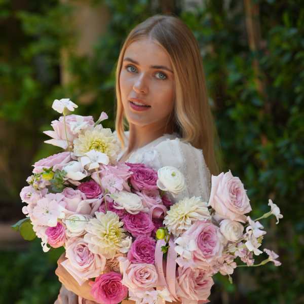 Woman holding a large bouquet of pink and white flowers