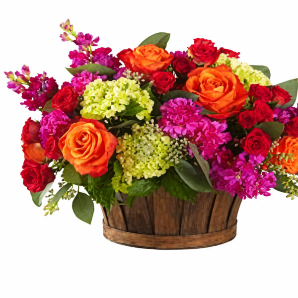 Mixed bouquet of roses and bright filler flowers in a wooden basket