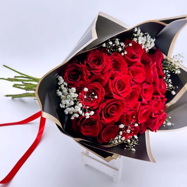 Bouquet of red roses with white baby's breath in black wrapping