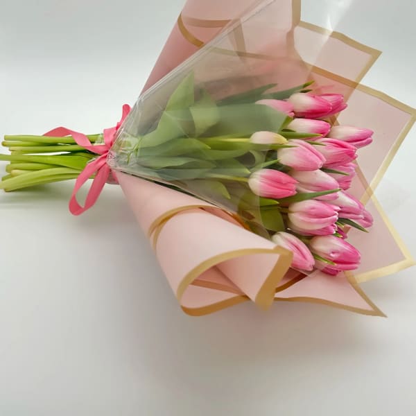 Bouquet of pink tulips wrapped in pink paper with clear plastic