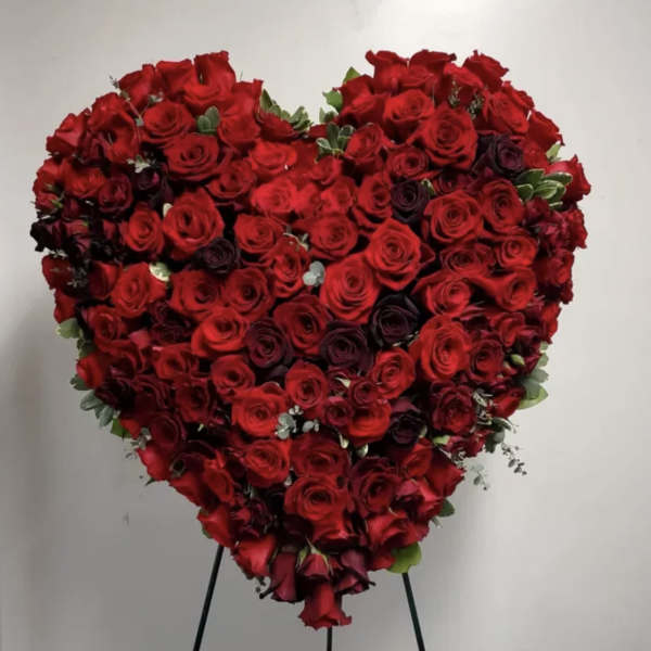 Heart-shaped arrangement of red roses on a stand