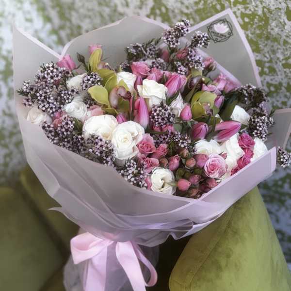 Pink and white bouquet with roses and lilies wrapped in pale paper