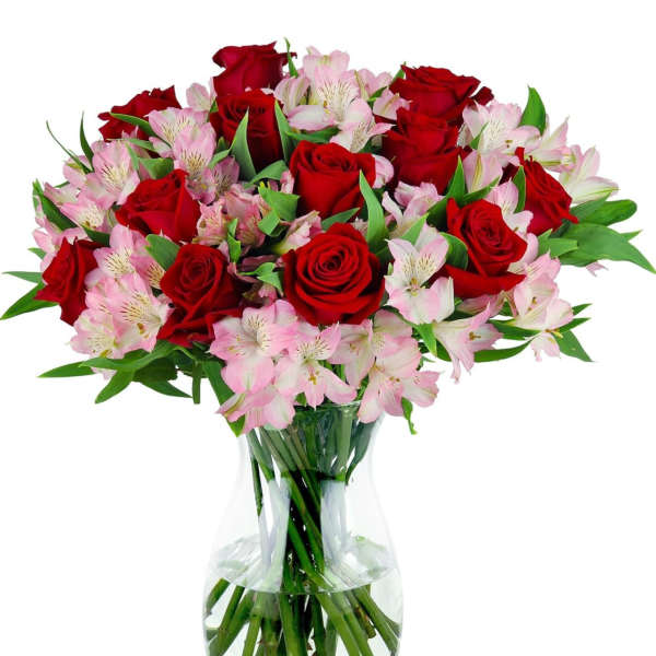 Red roses and pink alstroemeria in a clear glass vase