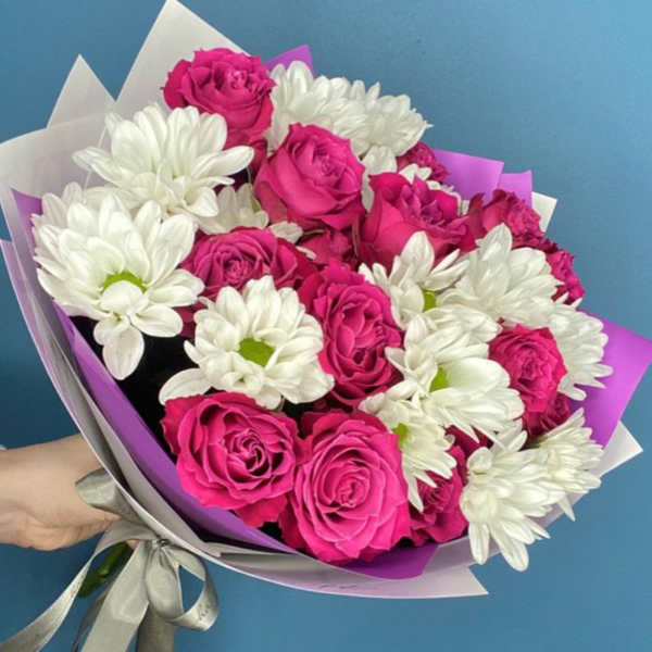 Bouquet of pink roses and white daisies wrapped in purple paper