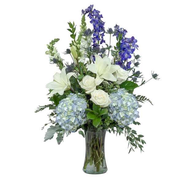 White lilies, roses, and blue flowers in a glass vase