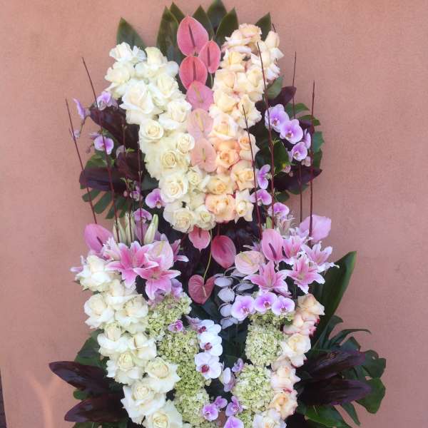 Standing floral funeral spray with white and pink roses, orchids, and lilies