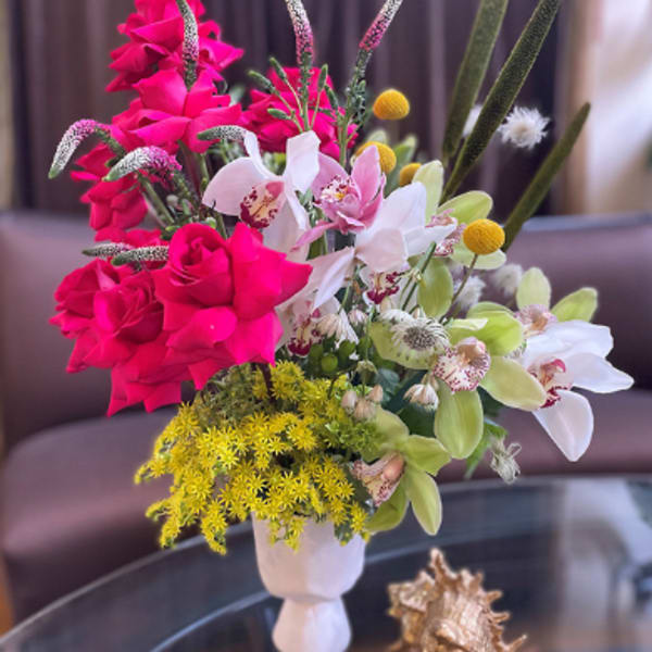 Bright mixed flower arrangement in a white vase
