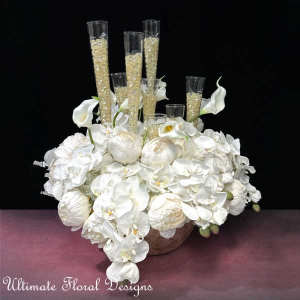 White floral arrangement with orchids, calla lilies, and tall glass cylinders