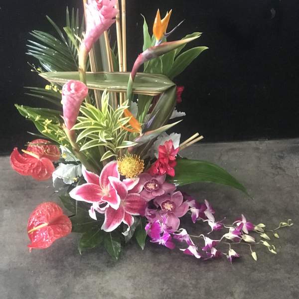 Tropical floral arrangement with orchids, lilies, and bird-of-paradise