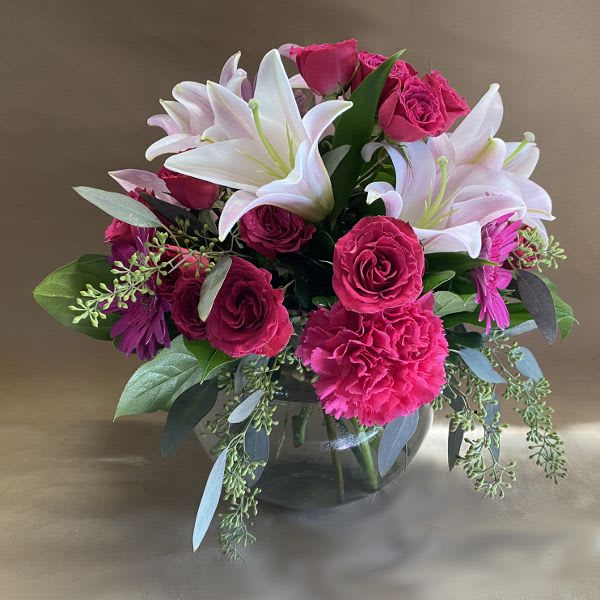 Pink roses and white lilies arranged in a glass vase