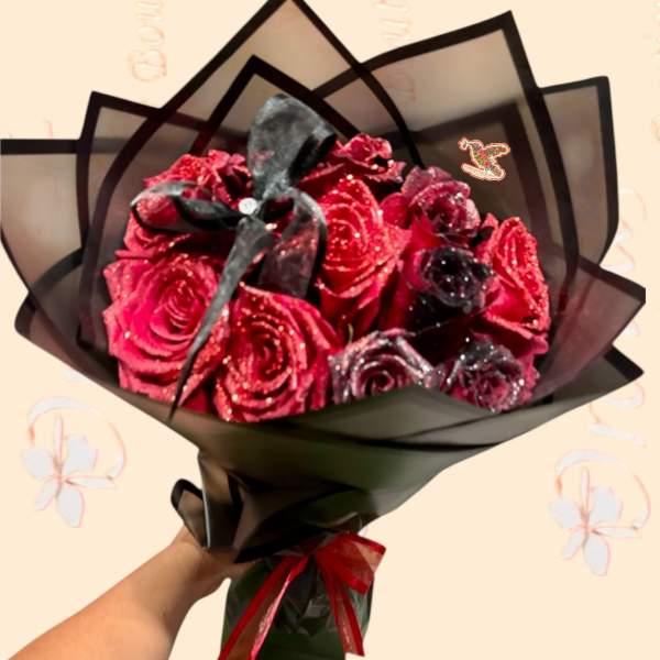 Bouquet of glittery red roses wrapped in black paper with a ribbon