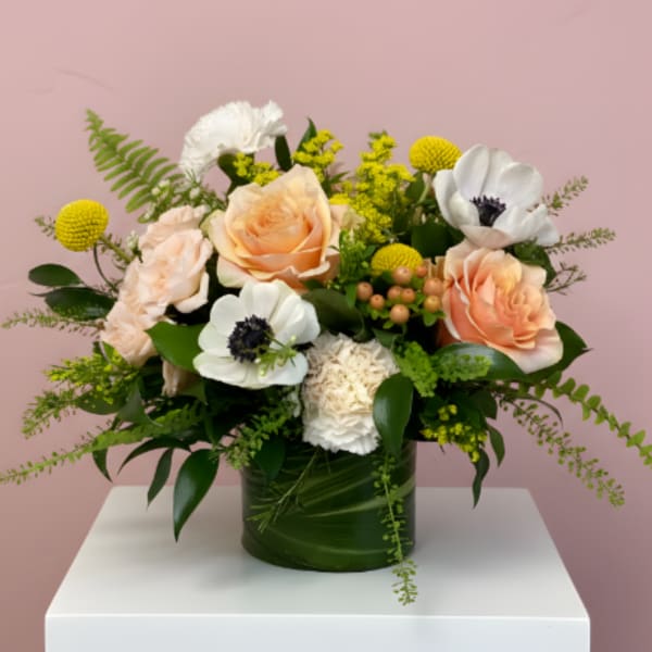 Peach roses and white anemones in a green vase