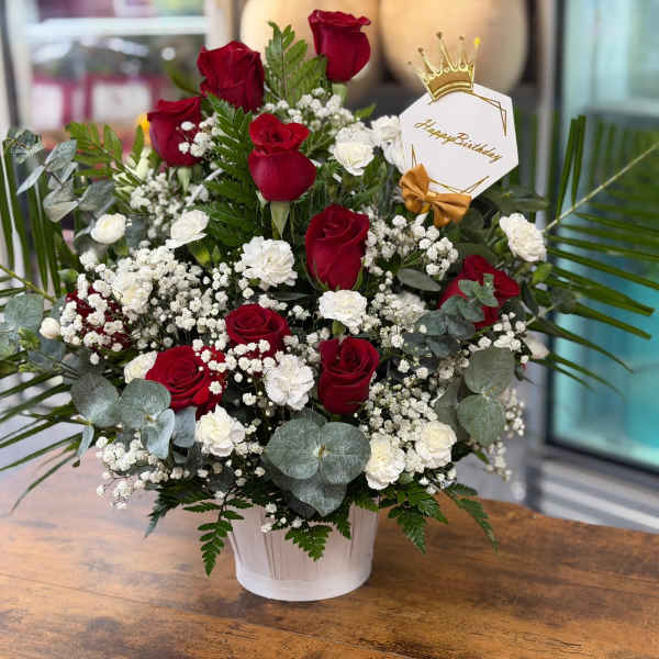 Red and white roses in a white pot with a birthday tag