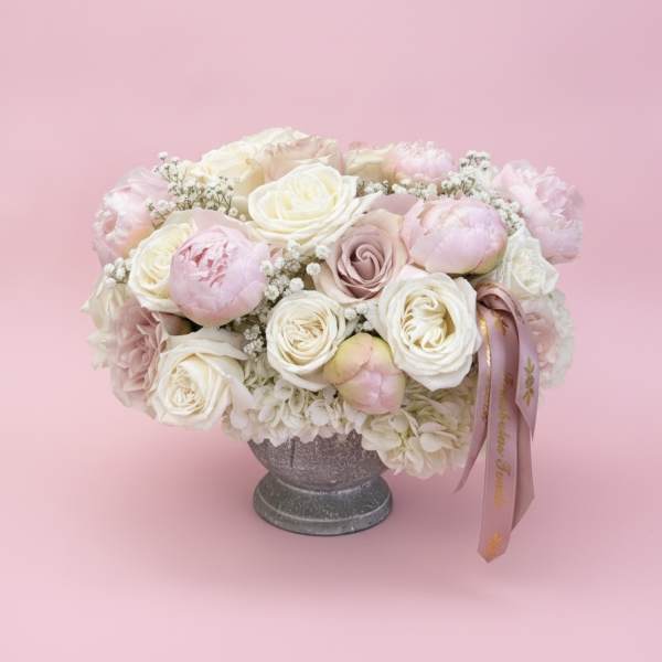 Pink and white rose bouquet in a gray pedestal vase