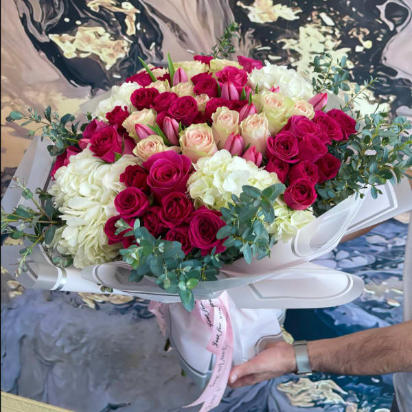 Large bouquet of pink and white roses with eucalyptus in white wrap