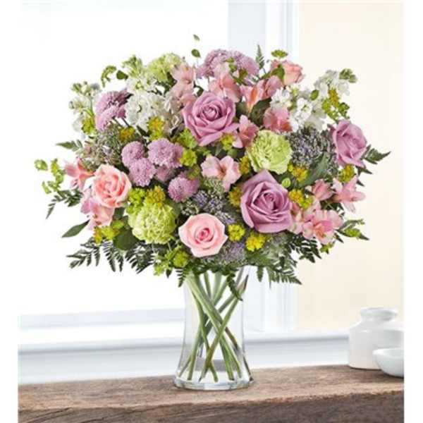 Bouquet of pink and lavender roses in a clear glass vase