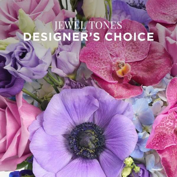 Close-up of jewel-toned bouquet with purple anemone, roses, lisianthus, orchids, and hydrangeas.