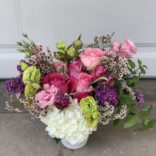 Mixed pink and white floral arrangement in a white vase