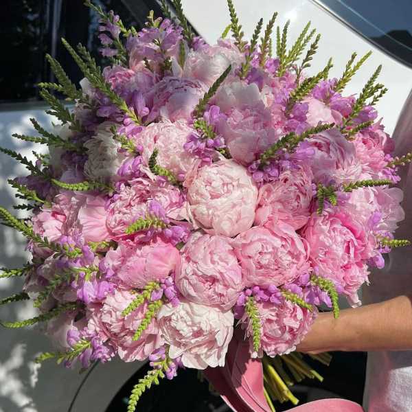 Bouquet of pink peonies and lavender flowers with long green spikes