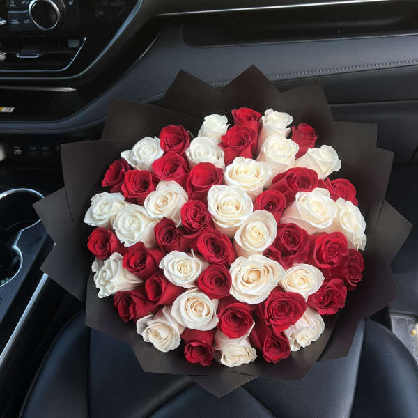 Bouquet of red and white roses wrapped in black paper